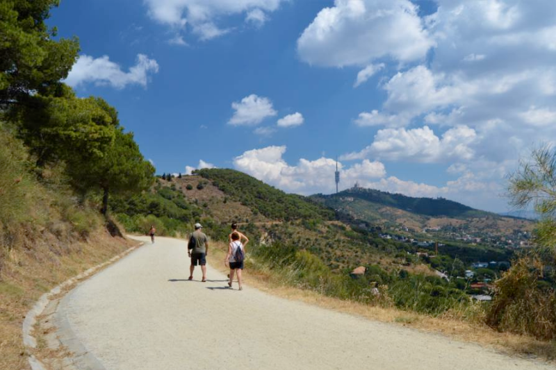 عائلة تمشي باريحية في طريق المياه (Carretera de les Aigües) المسطح في جبال كولسيرولا المطلة على برشلونة.