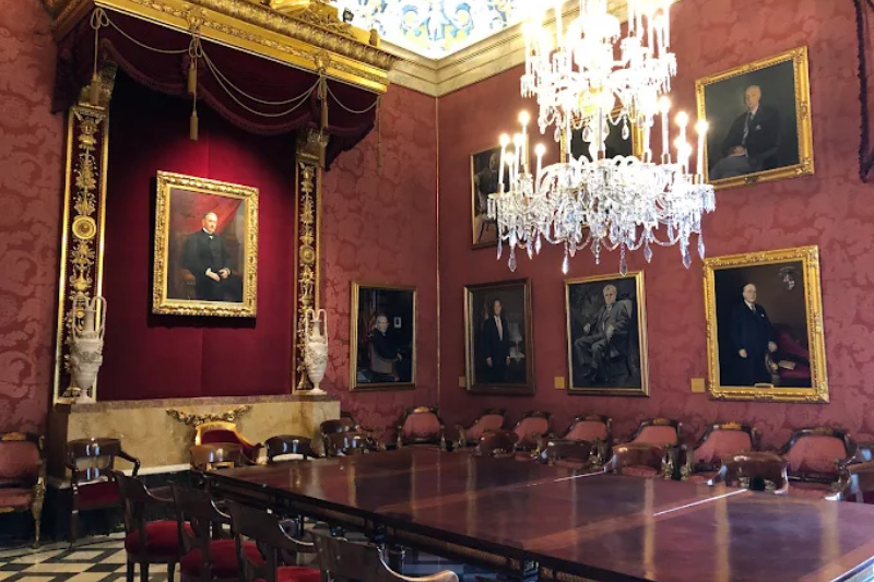 قاعة اجتماعات رسمية داخل Llotja de Mar بطاولة طويلة ولوحات بورتريه لاجتماعات الأعمال