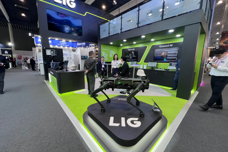 روبوت متقدم على شكل كلب معروض في جناح شركة (LIG)، تزامنا مع شعارات تركز على تقنيات الذكاء الاصطناعي المتصل (Connect AI) والتكنولوجيا للجميع (Tech 4 All)، ليمثل التطور المستمر في قطاع التنقل والآلات ذاتية التحكم.