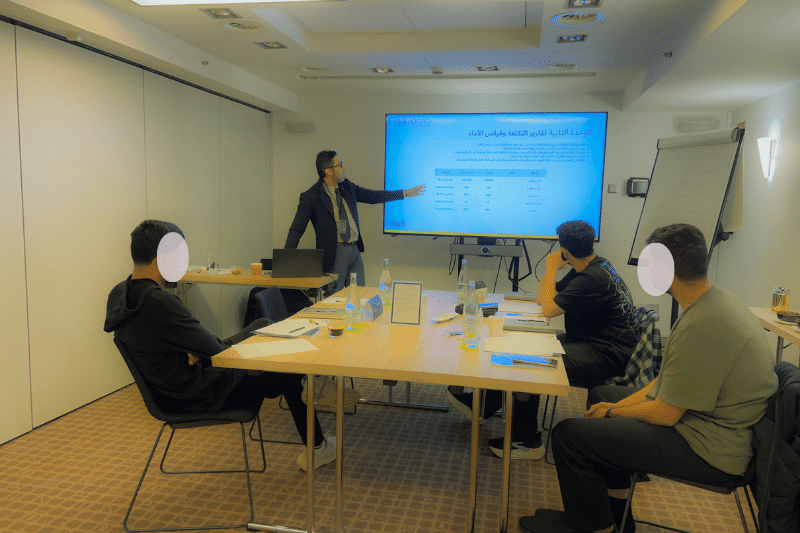 المدرب يشرح وحدة تقارير التكلفة وقياس الأداء لمتدربين في قاعة دورة المشتريات الاستراتيجية برشلونة 2026