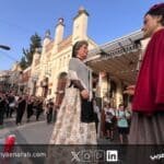 شخصيتان عملاقتان تقليديتان تسيران في موكب شعبي في كتالونيا وسط فرقة موسيقية وجمهور